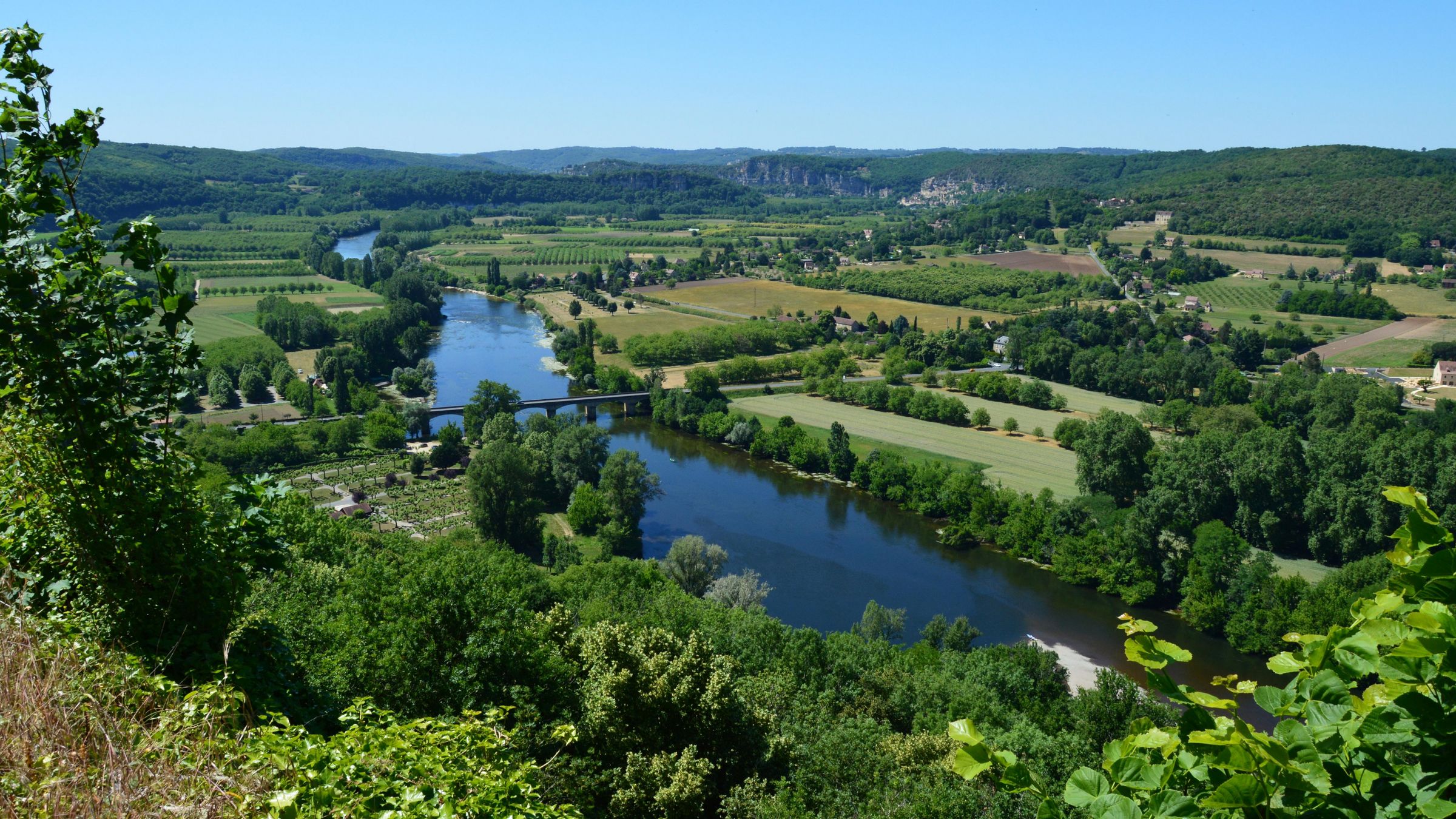 La vallée de la Dordogne vue du coteau, la rivière entre les prés et les bois.
